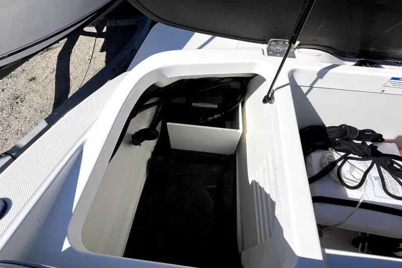 Slide: The Image of Open storage compartment of 2021 Sea Ray SPX 210 Outboard boat with ropes and equipment. - 13