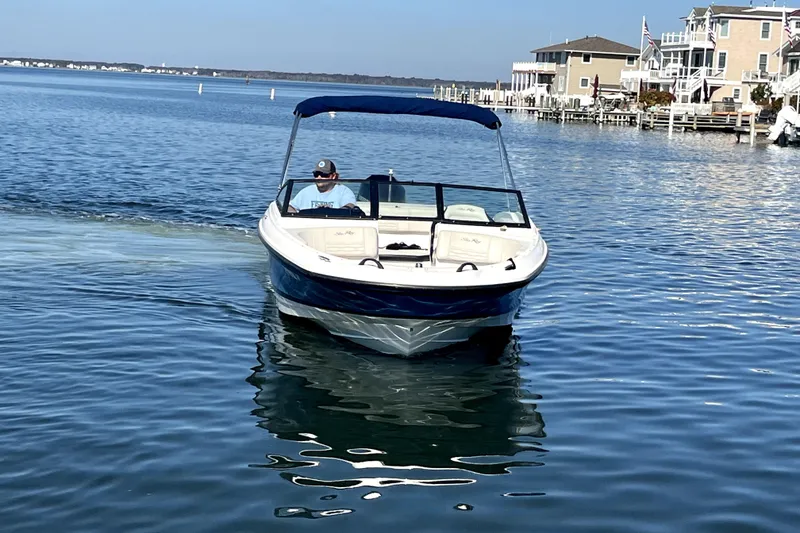 Slide: The Image of 2021 Sea Ray SPX 210 Outboard boat cruising on a calm waterfront near houses. - 6