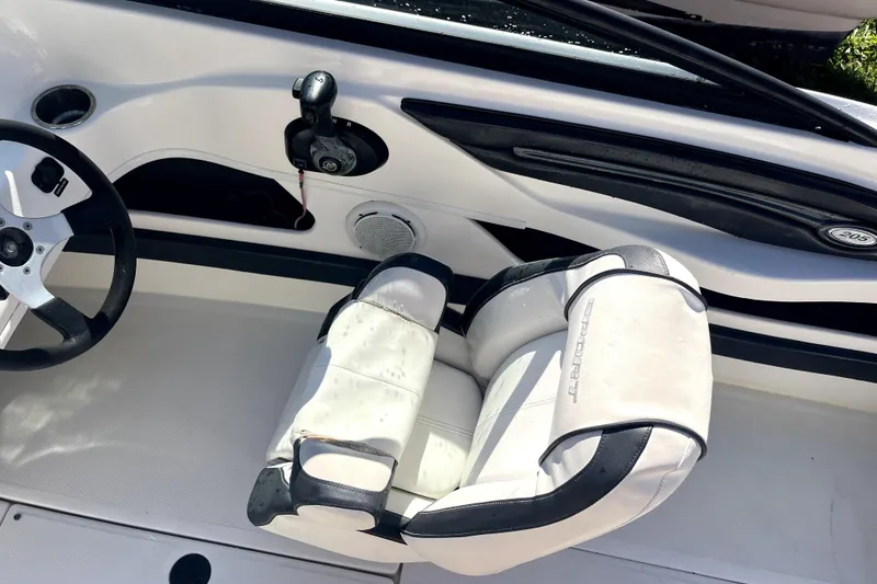 Slide: The Image of Interior of a 2012 Sea Ray 205 Sport boat, featuring steering wheel and seat. - 11