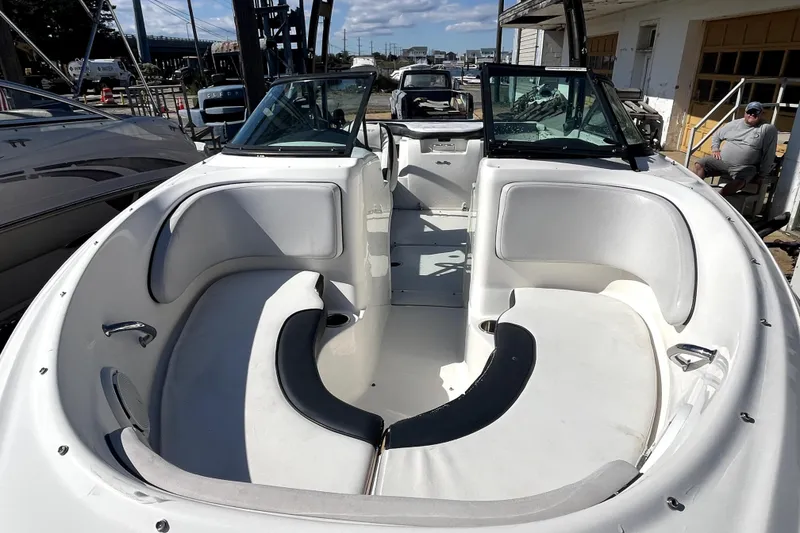 Slide: The Image of 2012 Sea Ray 205 Sport boat interior with white seating and open deck. - 13
