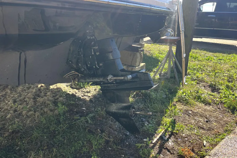 Slide: The Image of 2012 Sea Ray 205 Sport boat outdrive on grassy ground, sunlight highlighting details. - 3