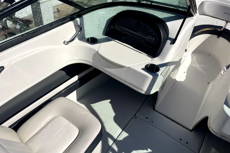 Slide: The Image of Interior of a 2012 Sea Ray 205 Sport boat, featuring seating and dashboard. - 9