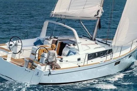 Slide: The Image of 2017 Beneteau Oceanis 38.1 yacht cockpit with dual steering wheels and wooden deck. - 0