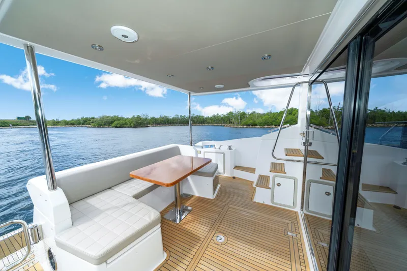 Slide: The Image of Luxurious 2018 Azimut 50 Fly yacht deck with seating, table, and scenic water view. - 12