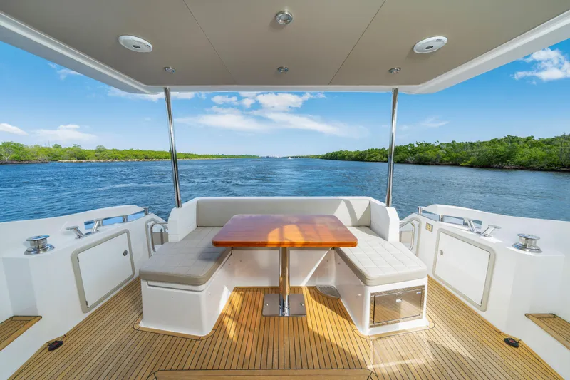 Slide: The Image of Luxurious Azimut 50 Fly yacht deck with seating, table, and scenic water view. - 13