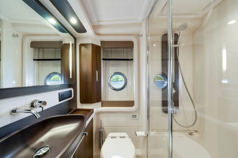 Slide: The Image of Luxurious bathroom interior of 2018 Azimut 50 Fly yacht with modern fixtures and porthole window. - 29