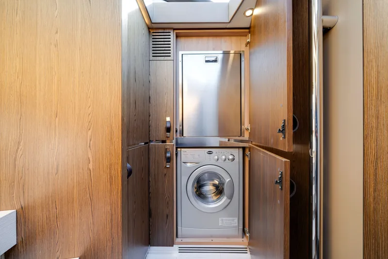 Slide: The Image of Laundry area in 2018 Azimut 50 Fly yacht with wood paneling and washing machine. - 30