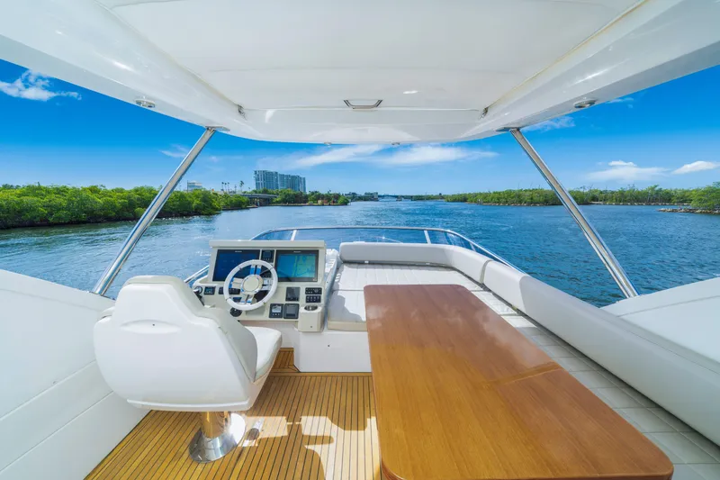 Slide: The Image of Flybridge view of 2018 Azimut 50 Fly yacht, featuring helm and seating area. - 38