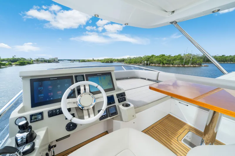 Slide: The Image of Helm of 2018 Azimut 50 Fly yacht with modern controls and scenic waterway view. - 39