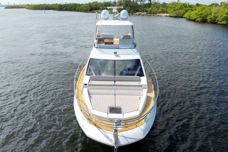 Slide: The Image of 2018 Azimut 50 Fly yacht cruising on a serene waterway, surrounded by lush greenery. - 4