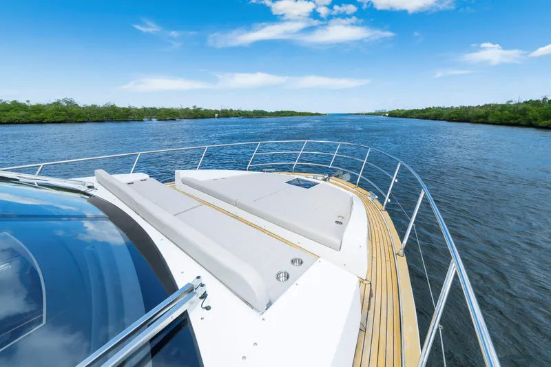 Slide: The Image of Luxurious 2018 Azimut 50 Fly yacht cruising on a serene river under a clear blue sky. - 42