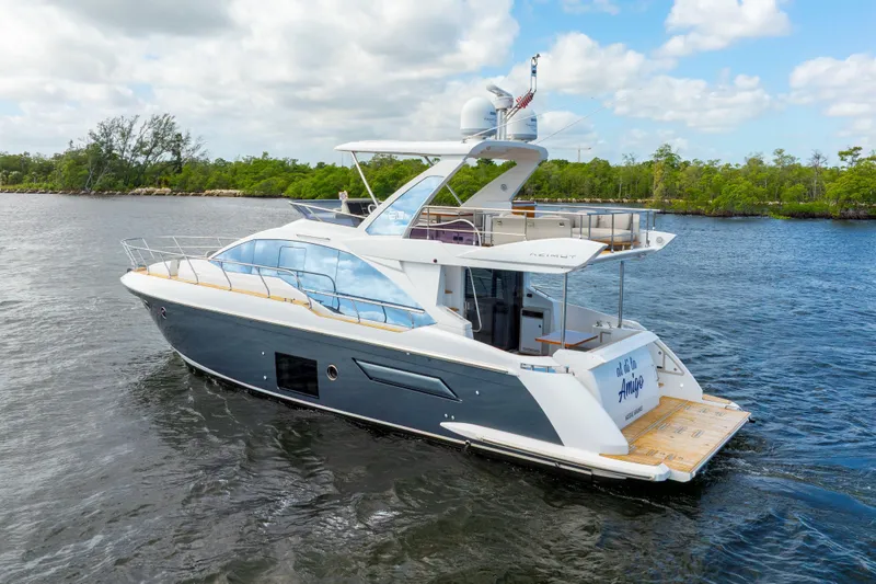 Slide: The Image of 2018 Azimut 50 Fly yacht cruising on a scenic waterway under a partly cloudy sky. - 7
