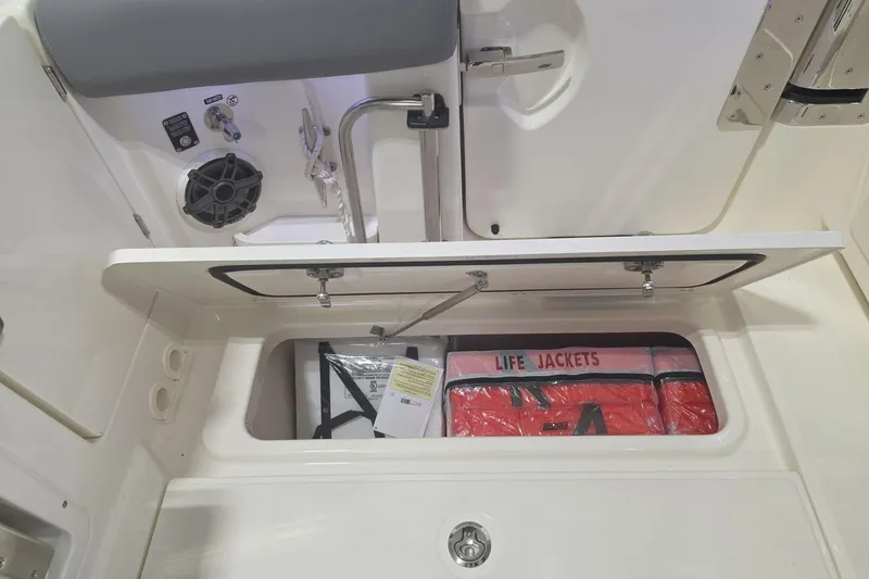 Slide: The Image of Storage compartment on 2026 Boston Whaler 380 Realm with life jackets and safety equipment. - 19