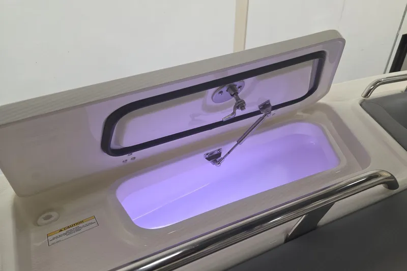 Slide: The Image of Open storage compartment with purple lighting on 2026 Boston Whaler 380 Realm boat. - 25