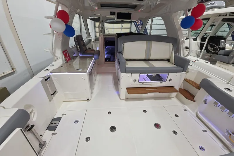 Slide: The Image of 2026 Boston Whaler 380 Realm interior with seating, storage, and festive balloons. - 26
