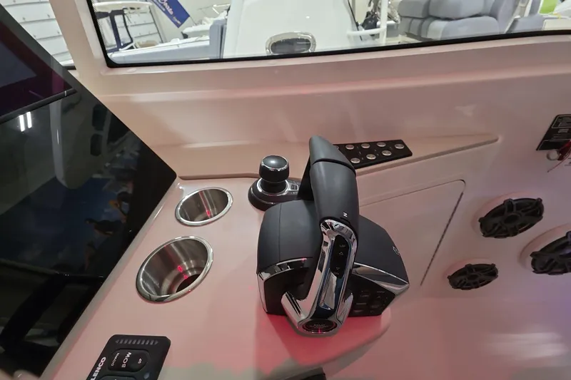 Slide: The Image of Control panel of 2026 Boston Whaler 380 Realm boat with joystick and cup holders. - 28