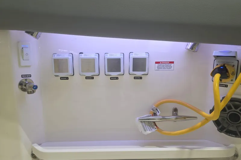 Slide: The Image of Boston Whaler 380 Realm 2026 electrical panel with shore power connections and fresh water access. - 36