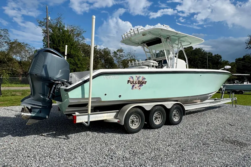 Slide: The Image of 2010 Venture 34 Tournament boat on trailer, featuring outboard motor and sleek design. - 3