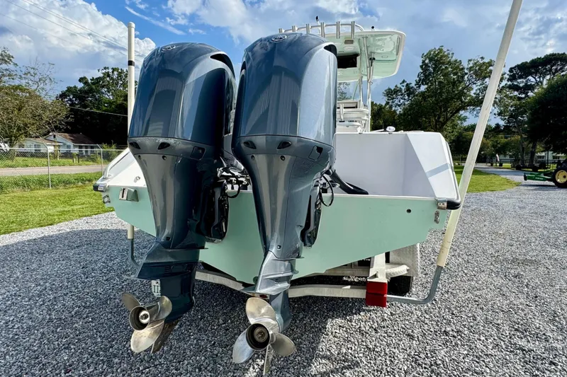 Slide: The Image of 2010 Venture 34 Tournament boat with dual outboard motors on gravel driveway. - 5