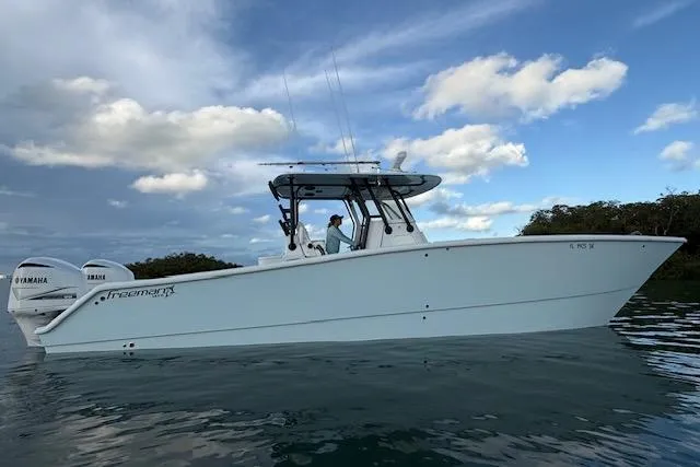 Slide: The Image of 2019 Freeman 34 boat on water with Yamaha engines, under a partly cloudy sky. - 10
