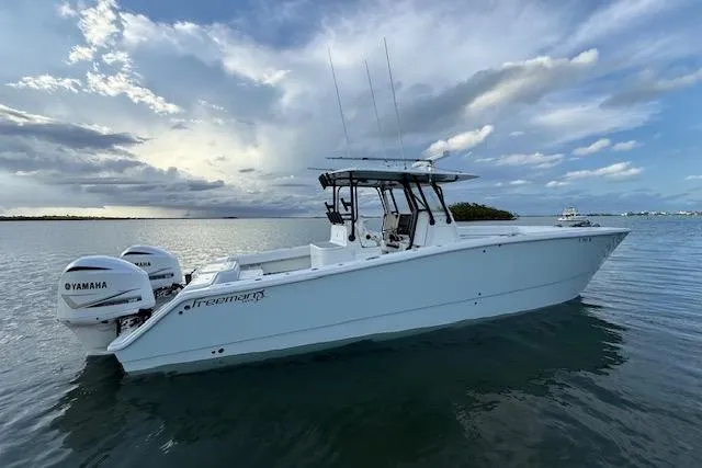 Slide: The Image of 2019 Freeman 34 boat with Yamaha engines on calm water under a cloudy sky. - 13