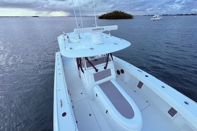 Slide: The Image of 2019 Freeman 34 boat on calm water, featuring Garmin equipment, under a cloudy sky. - 36