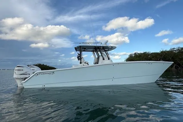 Slide: The Image of 2019 Freeman 34 boat with Yamaha engines on calm water under a blue sky. - 4