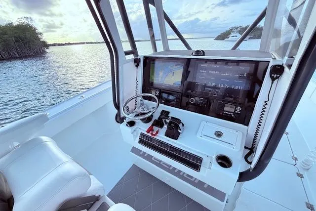 Slide: The Image of 2019 Freeman 34 boat cockpit with advanced navigation system and scenic water view. - 51