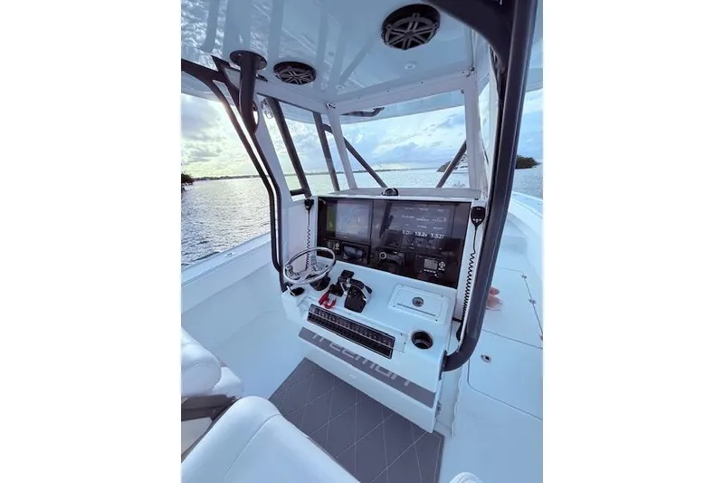 Slide: The Image of 2019 Freeman 34 boat cockpit with modern navigation equipment, overlooking serene water. - 52