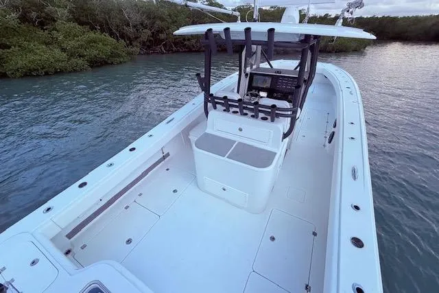 Slide: The Image of 2019 Freeman 34 boat with spacious deck and modern console, docked near lush greenery. - 55