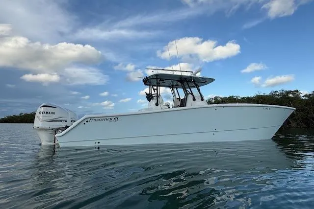 Slide: The Image of 2019 Freeman 34 boat on calm water with Yamaha engine, under a partly cloudy sky. - 9