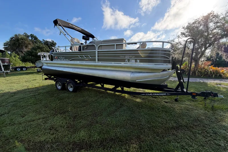 Slide: The Image of 2023 Sun Tracker Fishin' Barge 20 DLX pontoon boat on trailer, parked on grass. - 34