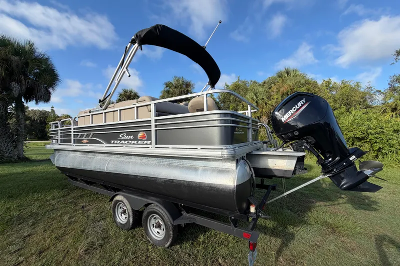 Slide: The Image of 2023 Sun Tracker Fishin' Barge 20 DLX pontoon boat on trailer, outdoor setting. - 35