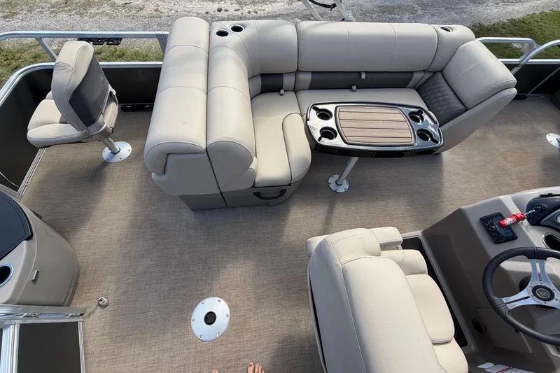 Slide: The Image of 2023 Sun Tracker Fishin' Barge 20 DLX interior with beige seating and table. - 39