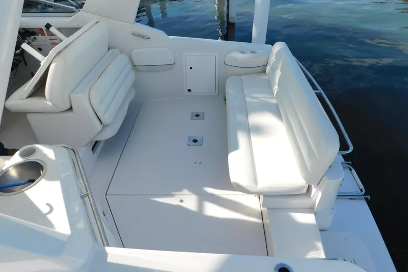Slide: The Image of 1996 Chris-Craft 340 Crowne boat interior with white seating and cup holder, docked on water. - 10