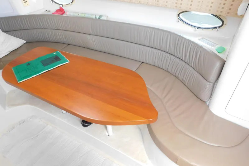 Slide: The Image of 1996 Chris-Craft 340 Crowne interior with curved seating and wooden table. - 63