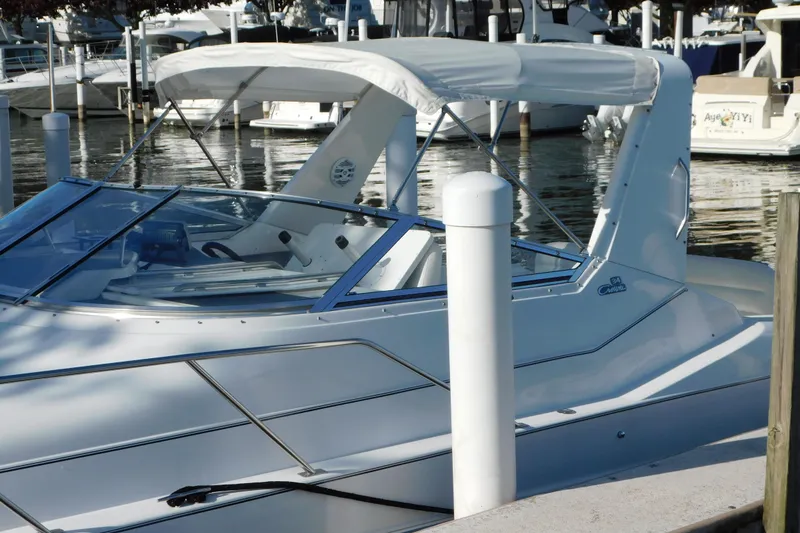 Slide: The Image of 1996 Chris-Craft 340 Crowne boat docked at marina, featuring sleek design and white canopy. - 8
