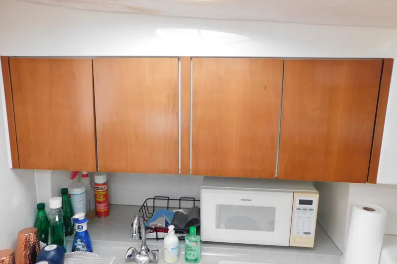 Slide: The Image of Wooden cabinets and kitchen counter in a 1996 Chris-Craft 340 Crowne boat. - 80