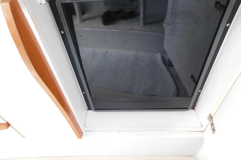 Slide: The Image of 1996 Chris-Craft 340 Crowne cabin door with wooden trim and reflective surface. - 81