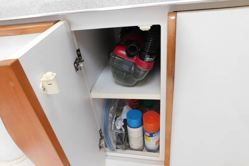 Slide: The Image of Open cabinet with cleaning supplies and vacuum in a 1996 Chris-Craft 340 Crowne boat. - 83