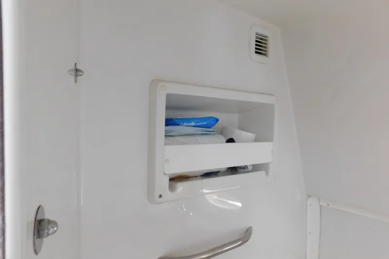 Slide: The Image of Storage compartment inside 1996 Chris-Craft 340 Crowne boat, featuring toiletries and ventilation. - 89