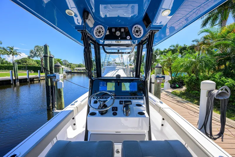 Slide: The Image of 2023 Sportsman Masters 247OE Bay Boat interior with modern dashboard and scenic marina view. - 16
