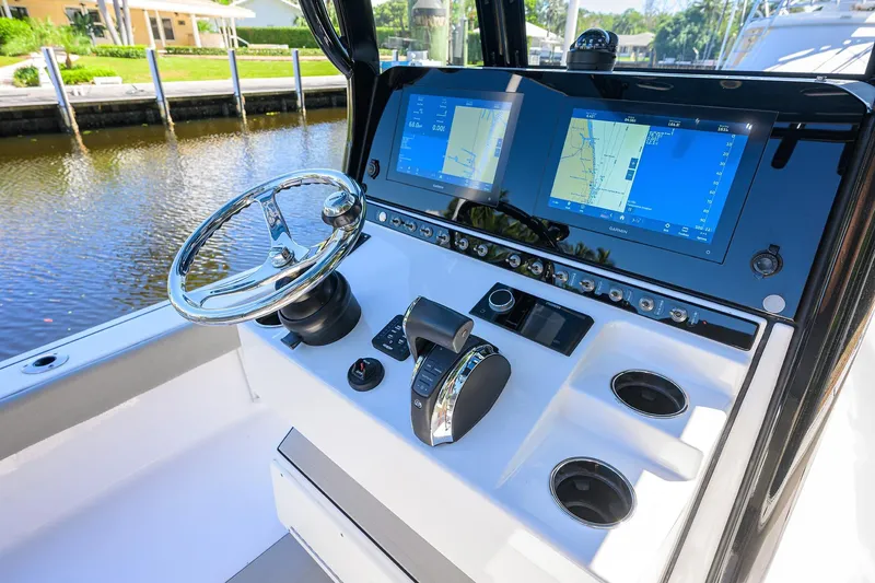 Slide: The Image of 2023 Sportsman Masters 247OE Bay Boat dashboard with dual navigation screens and steering wheel. - 17