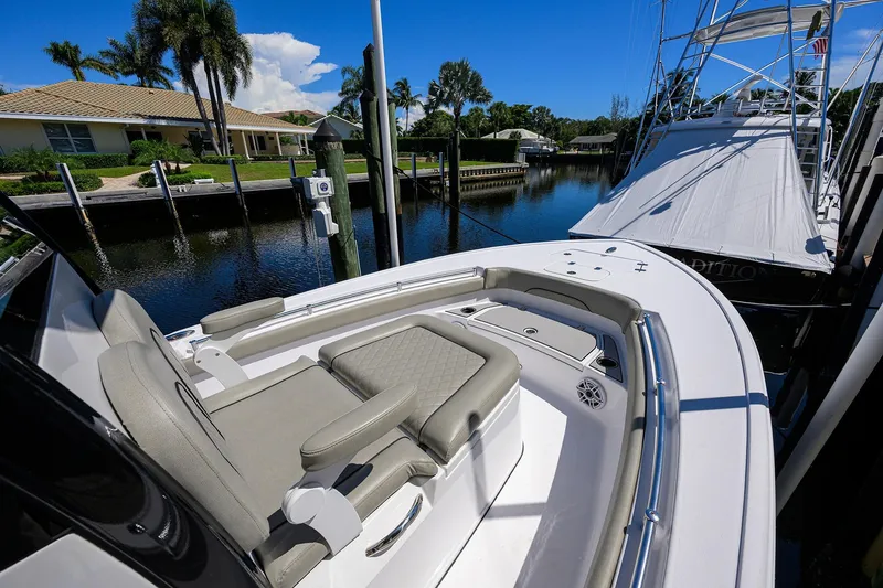 Slide: The Image of 2023 Sportsman Masters 247OE Bay Boat docked in a scenic waterfront setting. - 21
