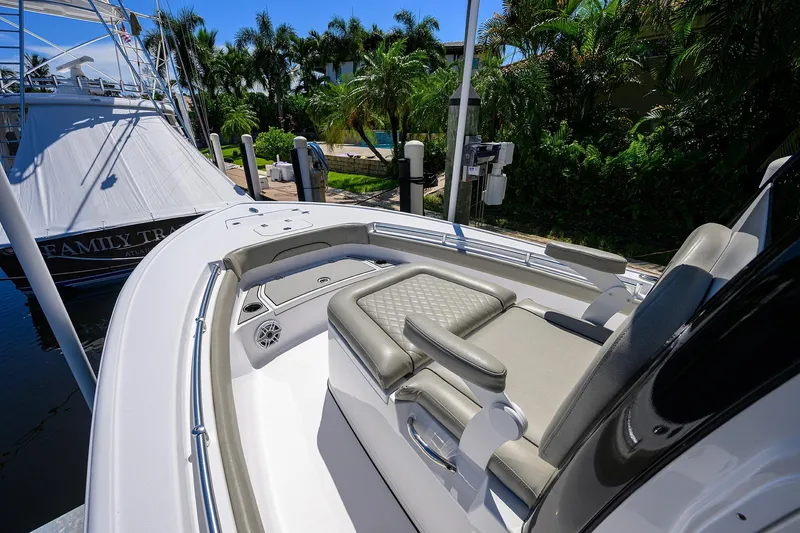 Slide: The Image of 2023 Sportsman Masters 247OE Bay Boat with luxurious seating, docked near lush greenery. - 22