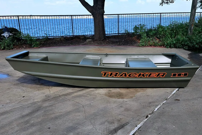 Slide: The Image of 2026 Tracker Grizzly 10 Jon boat on concrete near waterfront. - 32