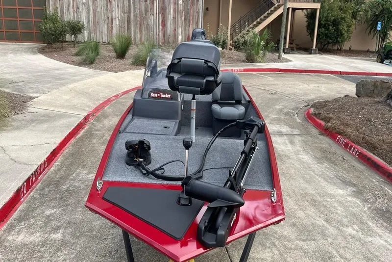 Slide: The Image of 2026 Tracker Bass Tracker Classic XL boat with red trim, parked on concrete. - 6