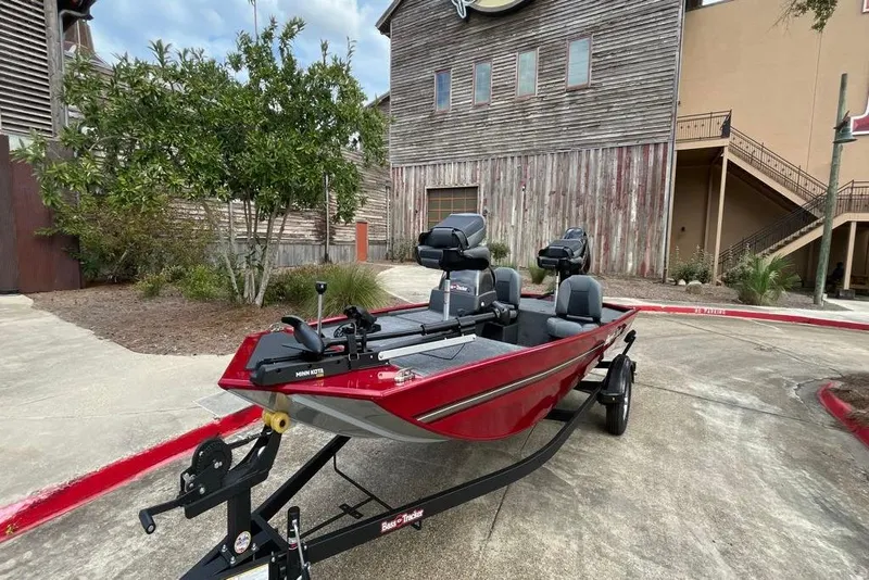Slide: The Image of 2026 Tracker Bass Tracker Classic XL boat parked outdoors, red color, on a trailer. - 7