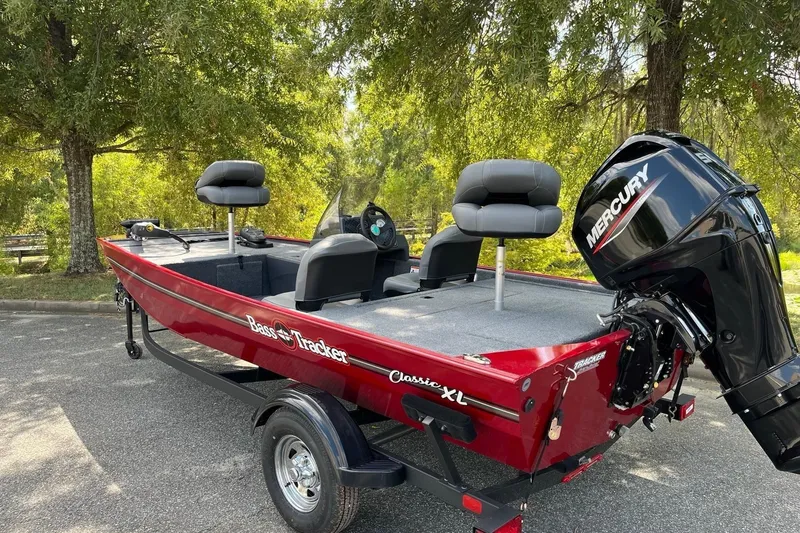 Slide: The Image of 2026 Tracker Bass Tracker Classic XL boat with Mercury engine, parked outdoors. - 2