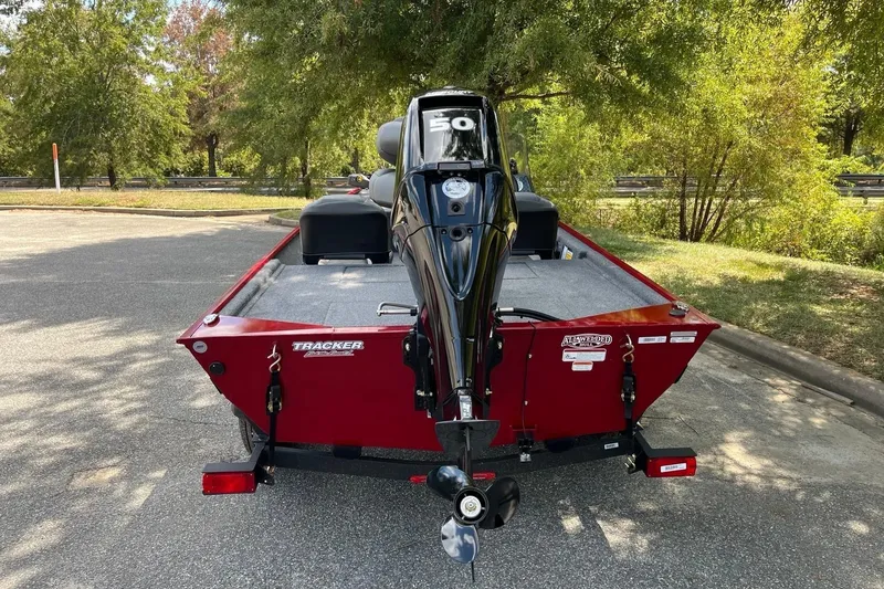 Slide: The Image of 2026 Tracker Bass Tracker Classic XL boat with outboard motor in a parking area. - 3